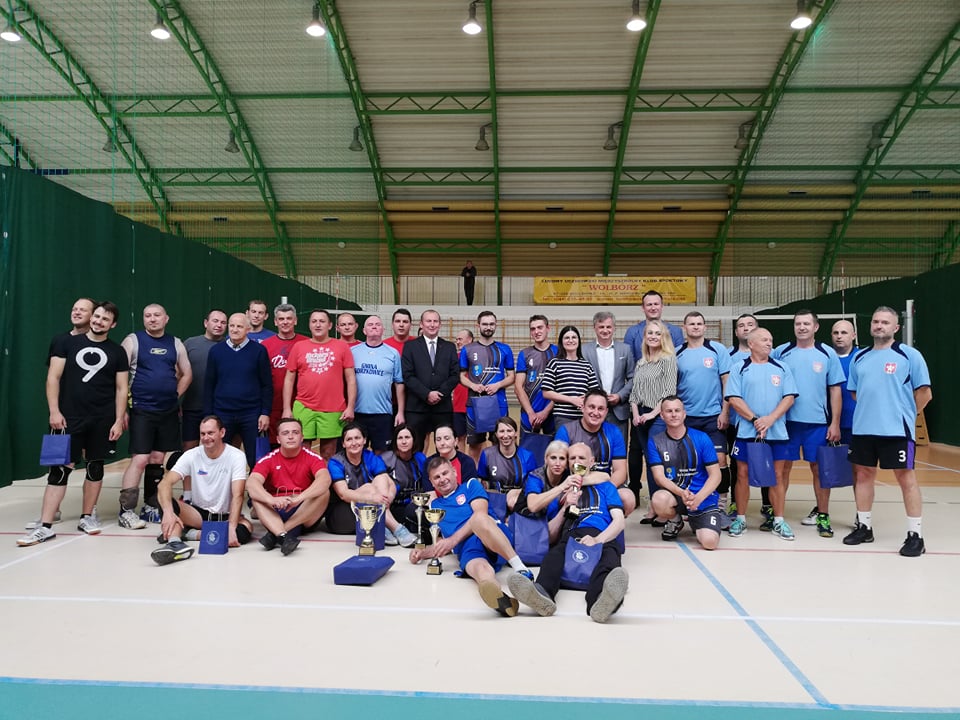 Grupa kilkunastu osób w hali sportowej.