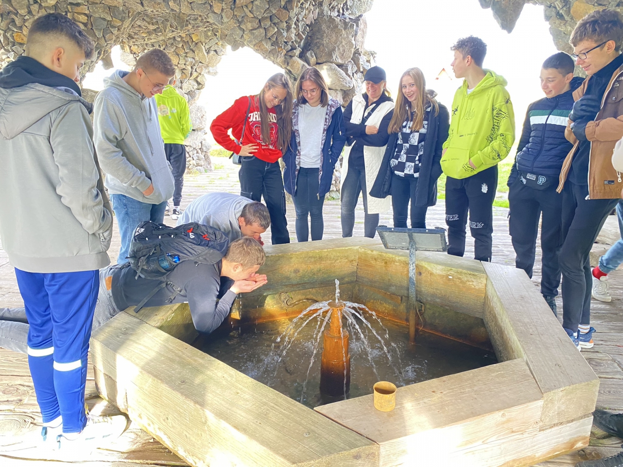 Uczniowie piją wodę z Królewskich Źródeł w Żerominie
