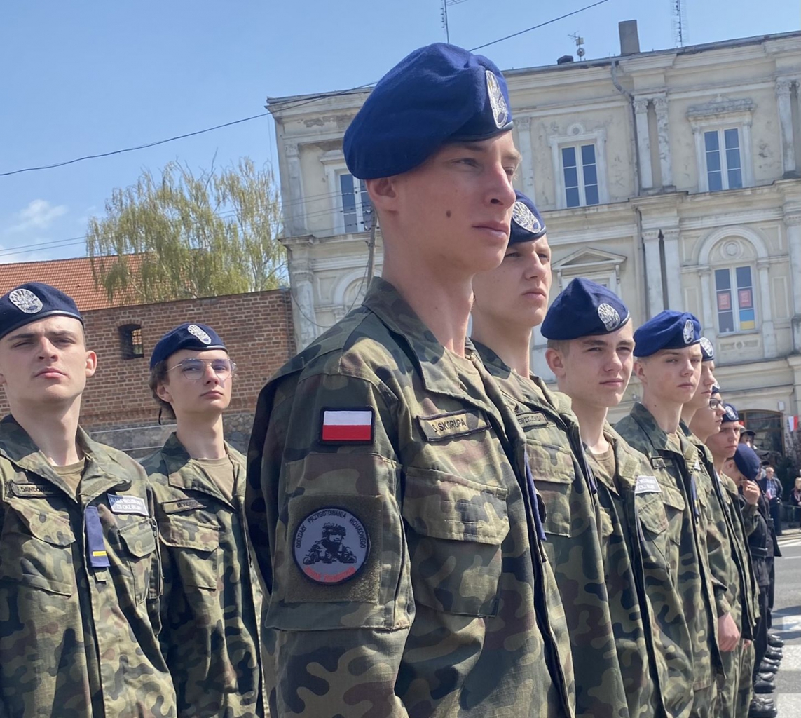 Młodzi chłopcy stoją na baczność w mundurach wojskowych