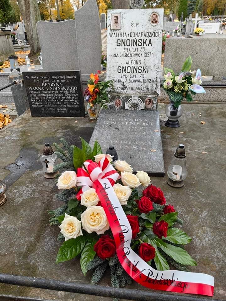 Grób rodziny Gnoińskich. Na nim wiązanka z biało czerwonych kwiatów.