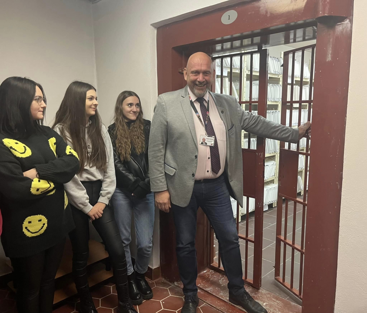 Sekretarz Powiatu wraz z uczniami stoi przy kratach