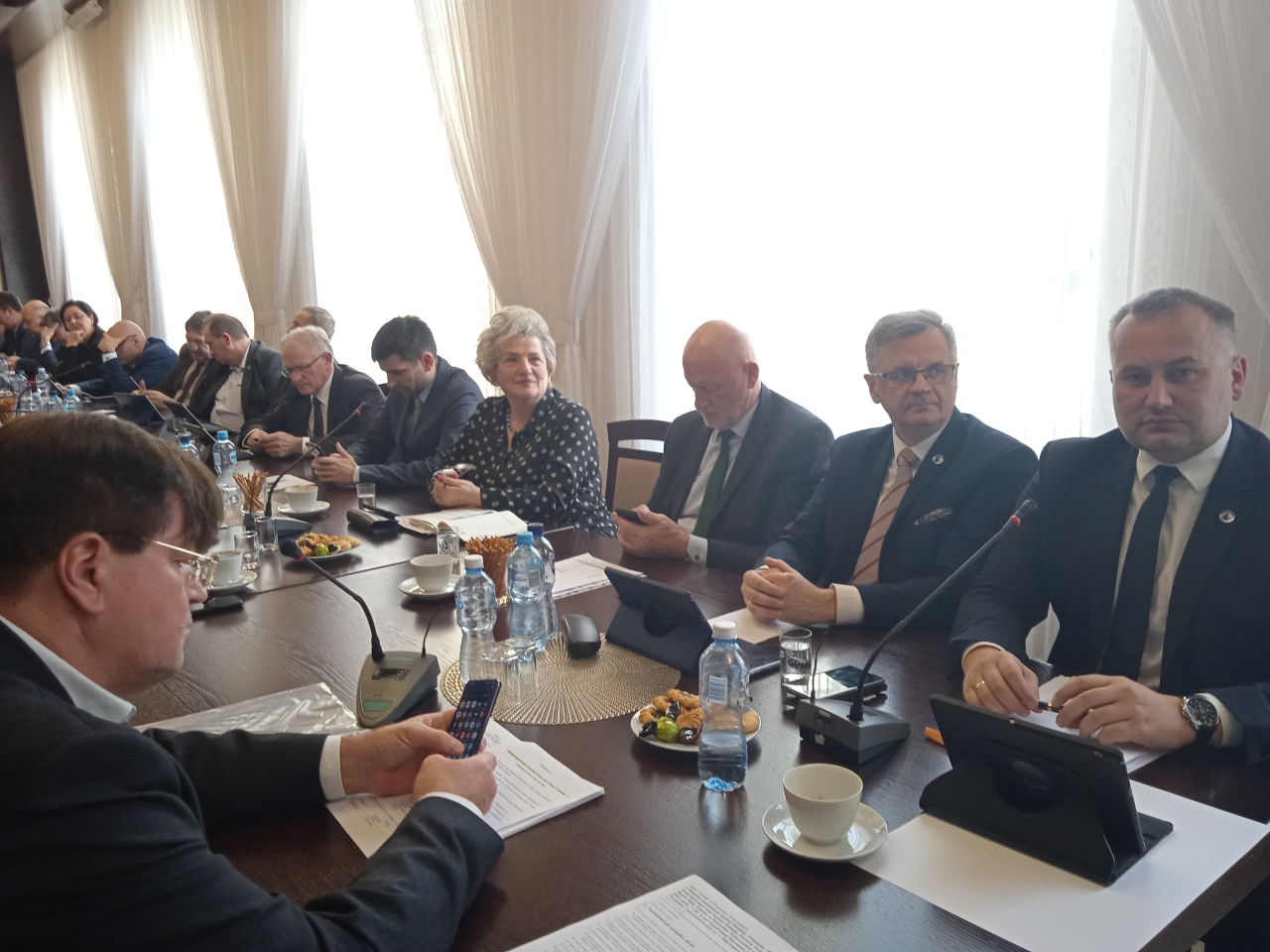 Starosta Piotr Wojtysiak oraz radni i zaproszeni goście znajdują się w sali konferencyjnej starostwa podczas Sesji.