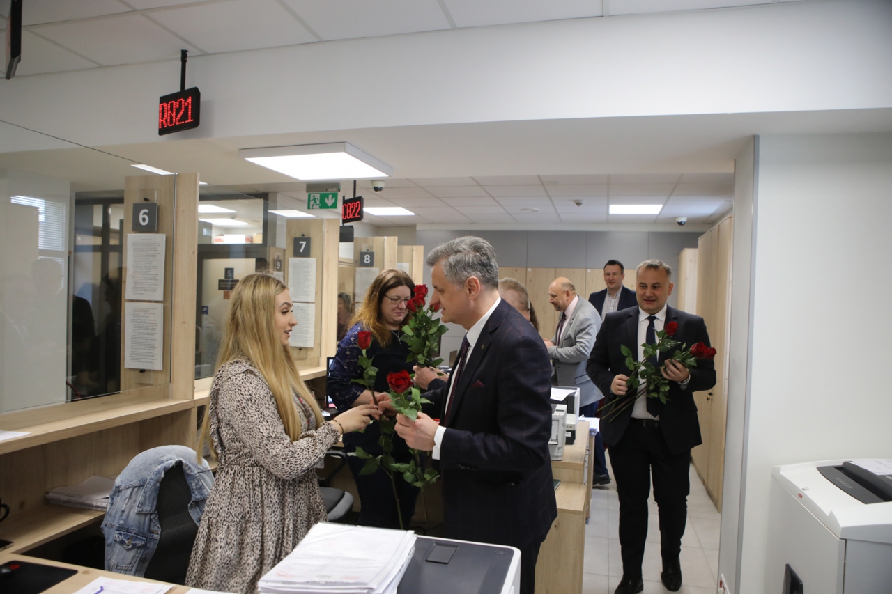 Starosta Piotr Wojtysiak i Wicestarosta Dariusz Magacz znajdują się w pomieszczeniu podczas wręczania kwiatów pracownicom. 