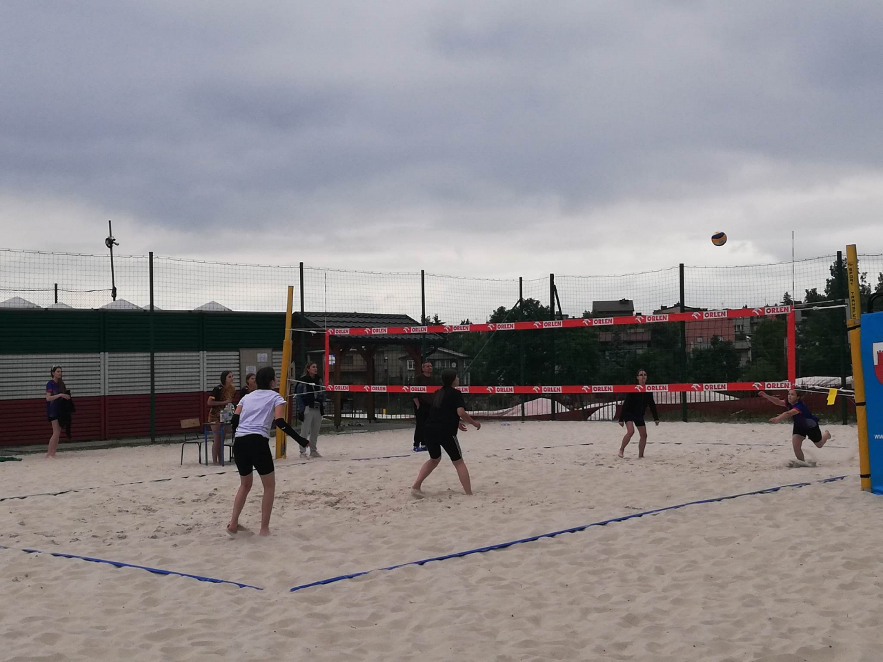 Zawodnicy grają na boisku siatkowej piłki plażowej