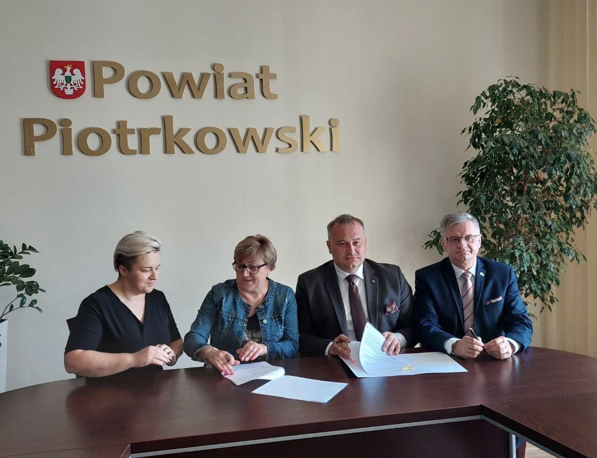 Władze Powiatu i Stowarzyszenia znajdują się w Sali konferencyjnej Starostwa. W tle napis Powiat Piotrkowski oraz herb Powiatu